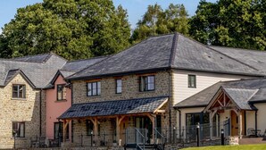 Ein zweistöckiges Steinhaus mit einer Veranda und einer Treppe, die zu dem oberen Stockwerk führt.