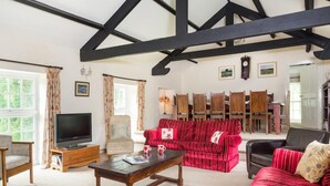 Una sala de estar con televisor, sofá, sillones y chimenea.