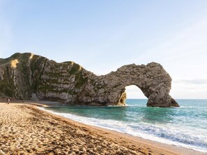 Uma praia com um arco natural de rocha.