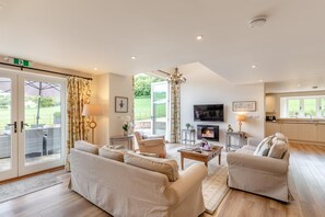 A spacious living room with a sofa set, a fireplace, and a television. - 3 Bed in Dorchester (oc-75244) (Sydling Saint Nicholas)