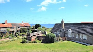 A residential area with houses, a bridge, and a view of the sea. - 3 Bed in Norwich (oc-75160) (Mundesley)