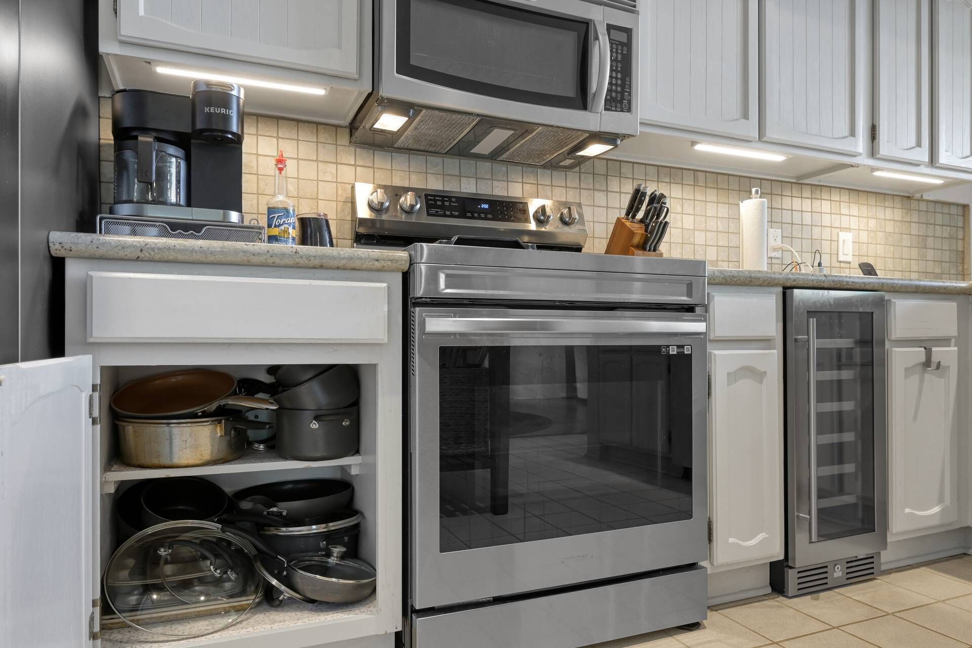 Una cucina moderna con elettrodomestici in acciaio inossidabile, tra cui un forno a microonde, un forno e una lavastoviglie.