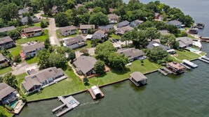 An aerial view of a residential area with houses, a dock, and a body of water. - Lakefront Townhome | Private Boat Slip | Swim + Fish | Pool Access | Near Ren Fest | Sleeps 8 (Montgomery)