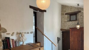 A wooden chest of drawers, a bust sculpture, and a staircase with a wooden handrail.