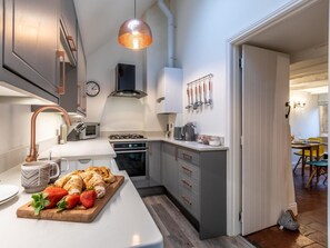 A modern kitchen with a central island, stainless steel appliances, and a hanging light fixture. - 3 Bed in Cheltenham (oc-75532) (Bourton-on-the-Water)