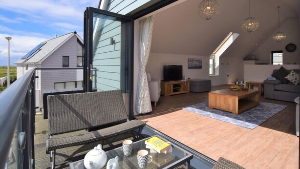 A spacious balcony with a glass table, wicker chairs, and a sofa. - 3 Bed in Bideford (oc-75539) (Northam)