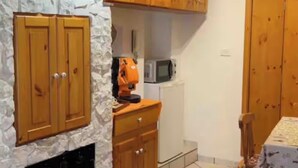 Una cocina con armarios de madera, un microondas y una estufa.