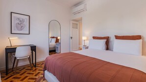 Hotellihuone, jossa on sänky, työpöytä, tuoli ja peili.