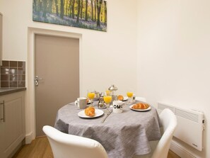 A dining area with a table set for breakfast, including croissants, orange juice, and coffee mugs. - 2 Bed in Middlesbrough (oc-75544) (Stokesley)