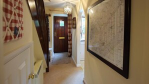 A hallway with a wooden door, a map on the wall, and a chandelier. - 2 Bed in Shipston-on-stour (oc-75870) (Whichford)