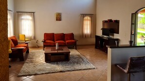 Una sala de estar con sofá, mesa de centro y mueble para televisión.