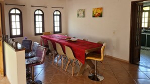 Un comedor con una mesa larga, sillas y un accesorio de iluminación decorativo.