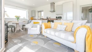 Un salon moderne avec un canapé, un fauteuil et une table à manger.