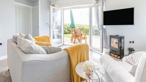 Un salon moderne avec un canapé, un fauteuil et une table sur laquelle est posé un vase.