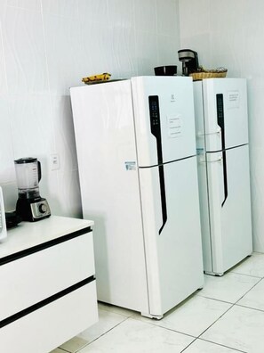 Two white refrigerators with black handles, a white countertop, and a blender. - Hostel Recanto da Paciência (Salvador)