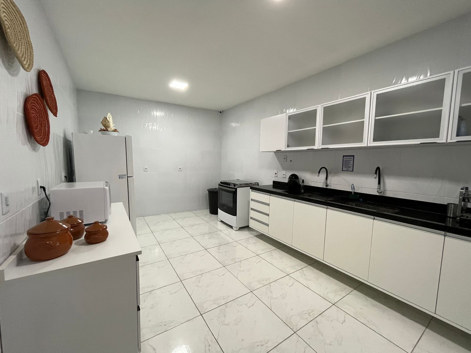 Cocina moderna con armarios blancos, encimera negra y estufa.