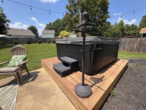 A hot tub on a wooden deck with a chair and a small table. - HOT TUB, Community Pool, AC, 5-Bedroom Oasis in Simpsonville (Simpsonville)