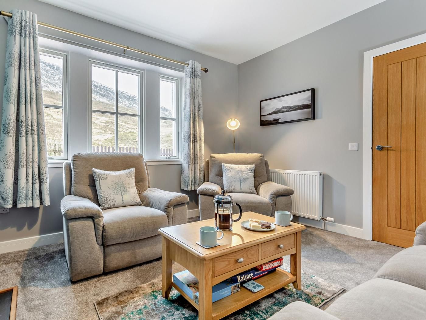 Un salon chaleureux avec deux fauteuils, une table basse et un radiateur.
