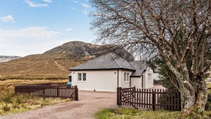 Une maison avec une allée en gravier et une clôture en bois.