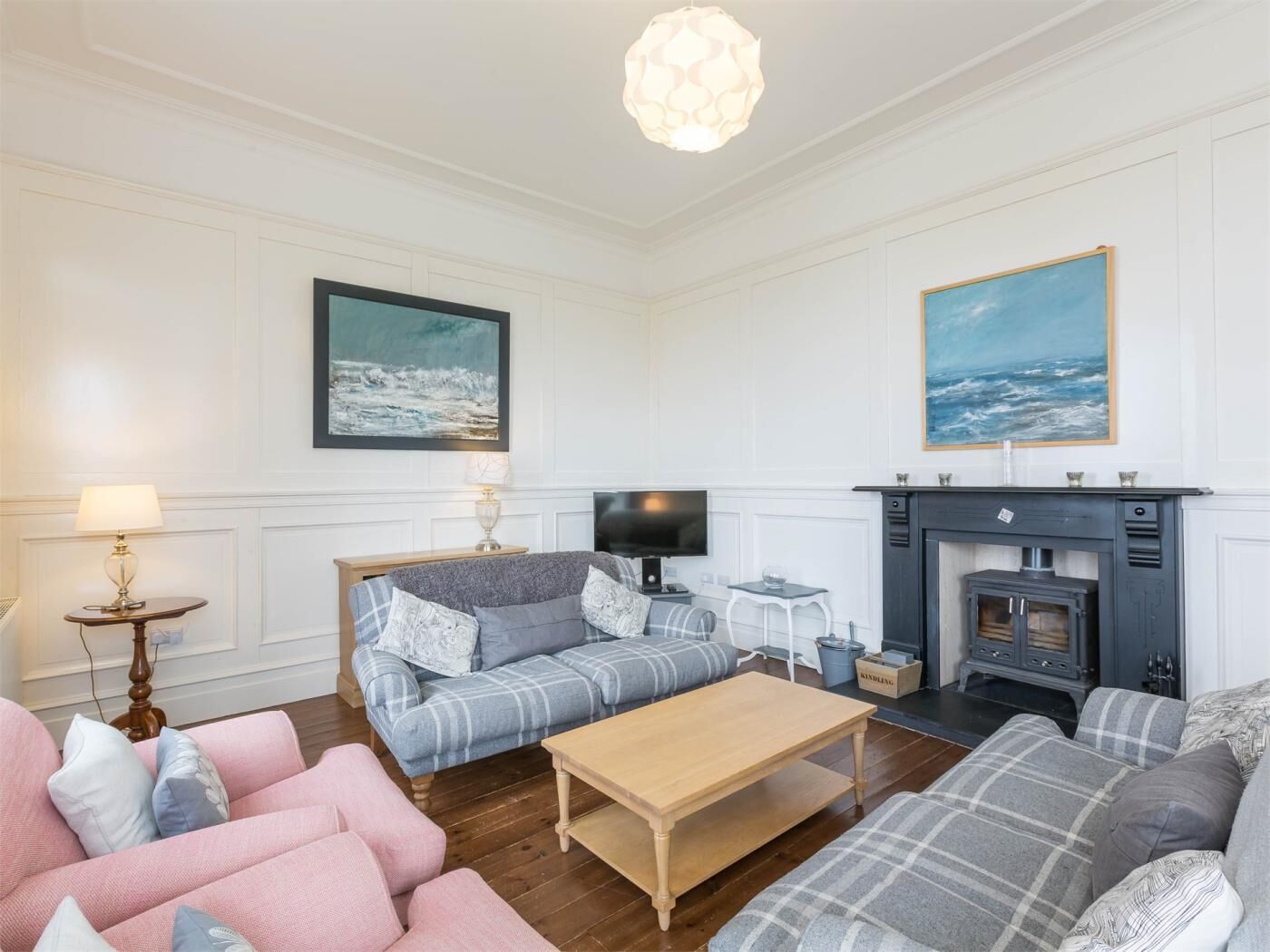 A living room with a fireplace, a sofa, a coffee table, and a television.