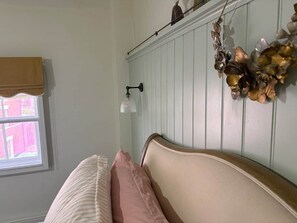 A bedroom with a bed, a window, a wall-mounted light, and a decorative plant. - Characterful Townhouse | Central 3 Bed + Parking (Ludlow)