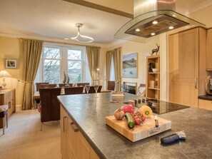 Une cuisine moderne dotée d’un îlot central, de meubles en bois et d’un coin repas avec des chaises.