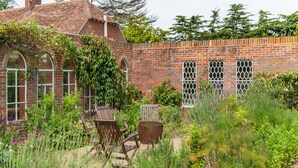 A brick building with arched windows and a garden area with outdoor furniture. - The Manor, Deal, Kent (Deal)