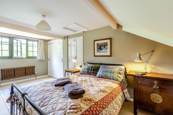 A bedroom with a bed, bedside lamps, a radiator, a window, and a door. - 2 Bed in Minehead (oc-77362) (Withypool)