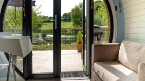 A modern room with a sliding glass door leading to an outdoor deck, a sofa, and a table.