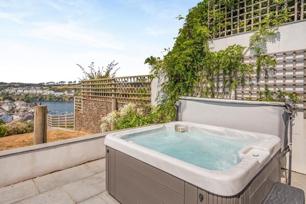 A hot tub on a rooftop with a view of a cityscape and a body of water. - 5 Bed in Fowey (oc-77657) (Polruan)