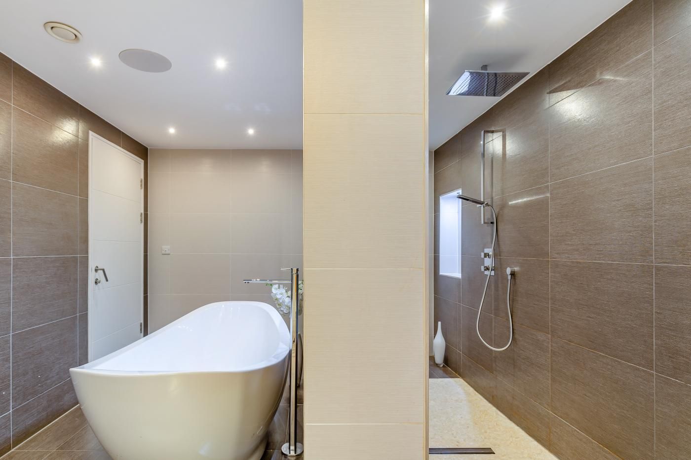 A modern bathroom with a freestanding bathtub, a shower area, and a toilet.