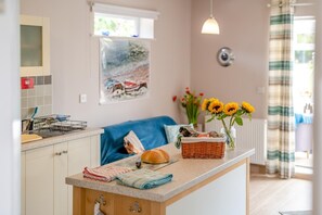 A kitchen with a countertop, a basket, a loaf of bread, and a vase with sunflowers. - 2 Bed in Bridlington (oc-77607) (Sewerby)