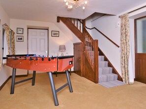 A room with a foosball table, a staircase, and a door. - 2 Bed in Colwyn Bay (oc-77635) (Colwyn Bay)