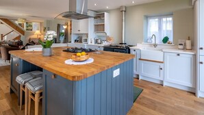Een moderne keuken met een centraal eiland, witte kastjes en een houten werkblad.