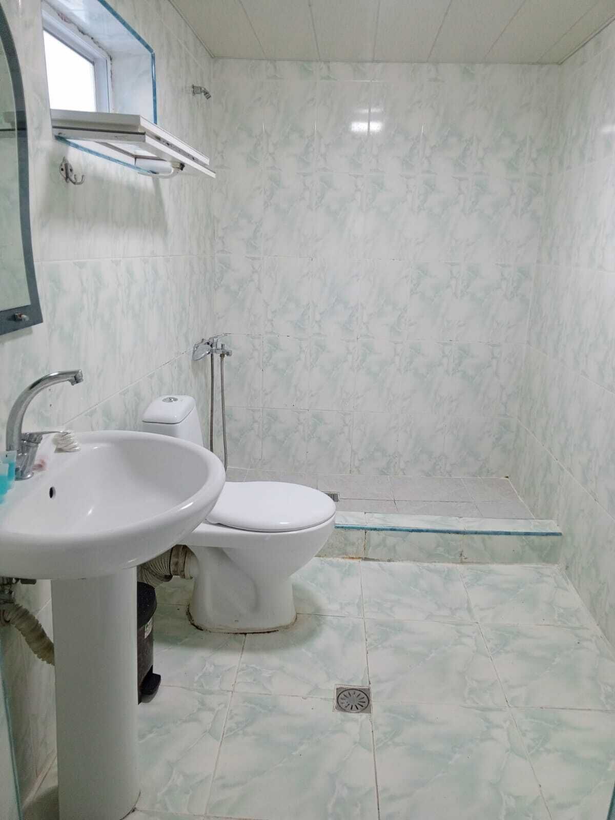 Un baño con lavamanos, inodoro y zona de ducha.