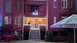 Un edificio de varios pisos con una entrada destacada y una escalera que conduce al nivel superior.