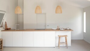 A modern kitchen with a wooden countertop, white cabinetry, and three woven pendant lights. - Villa Les Mouettes, Cap Ferret (Lège-Cap-Ferret)