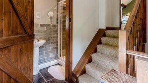 A wooden staircase leading to a bathroom with a sink and a mirror. - 1 Bed in Llangollen (oc-78471) (Glyn Ceiriog)