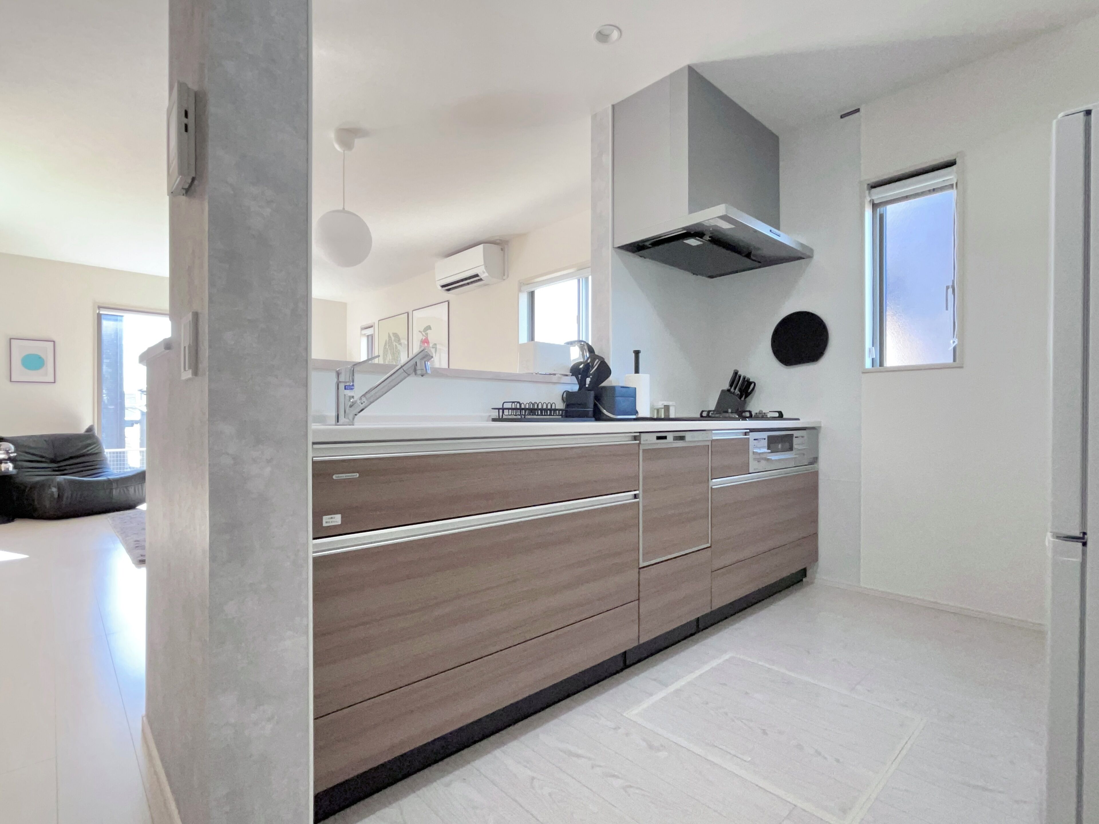 A modern kitchen with a large island, built-in appliances, and a window.