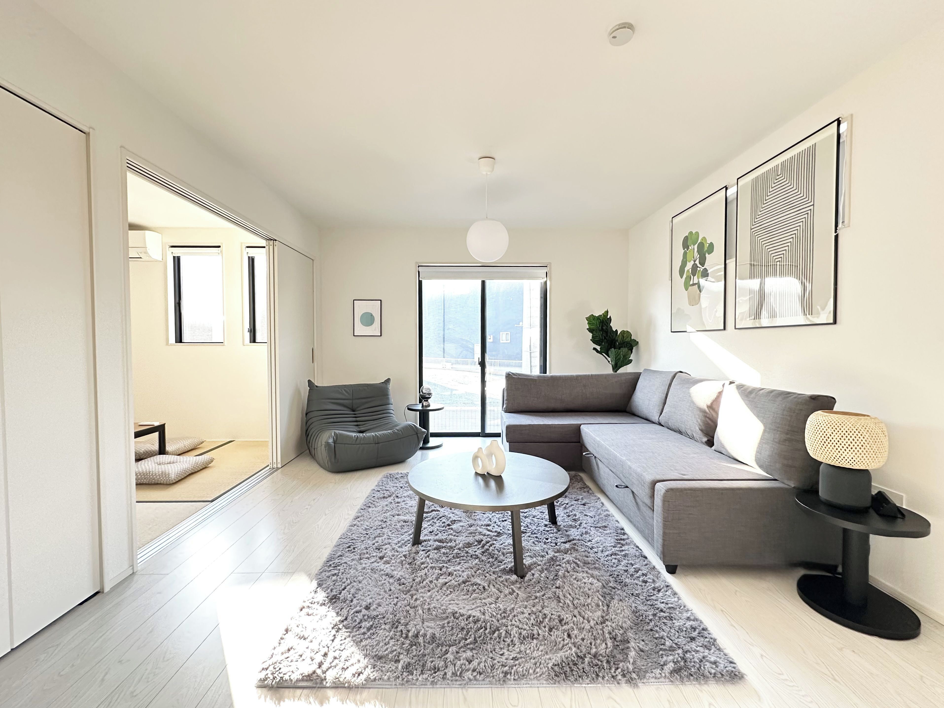 A modern living room with a grey sofa, a round coffee table, and a grey shag rug.