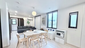 Ein zeitgemäßer Wohnbereich mit Essplatz, Sofa und Küche.