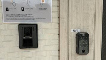 En dør med en Yale smartlås og et Panasonic overvågningskamera.
