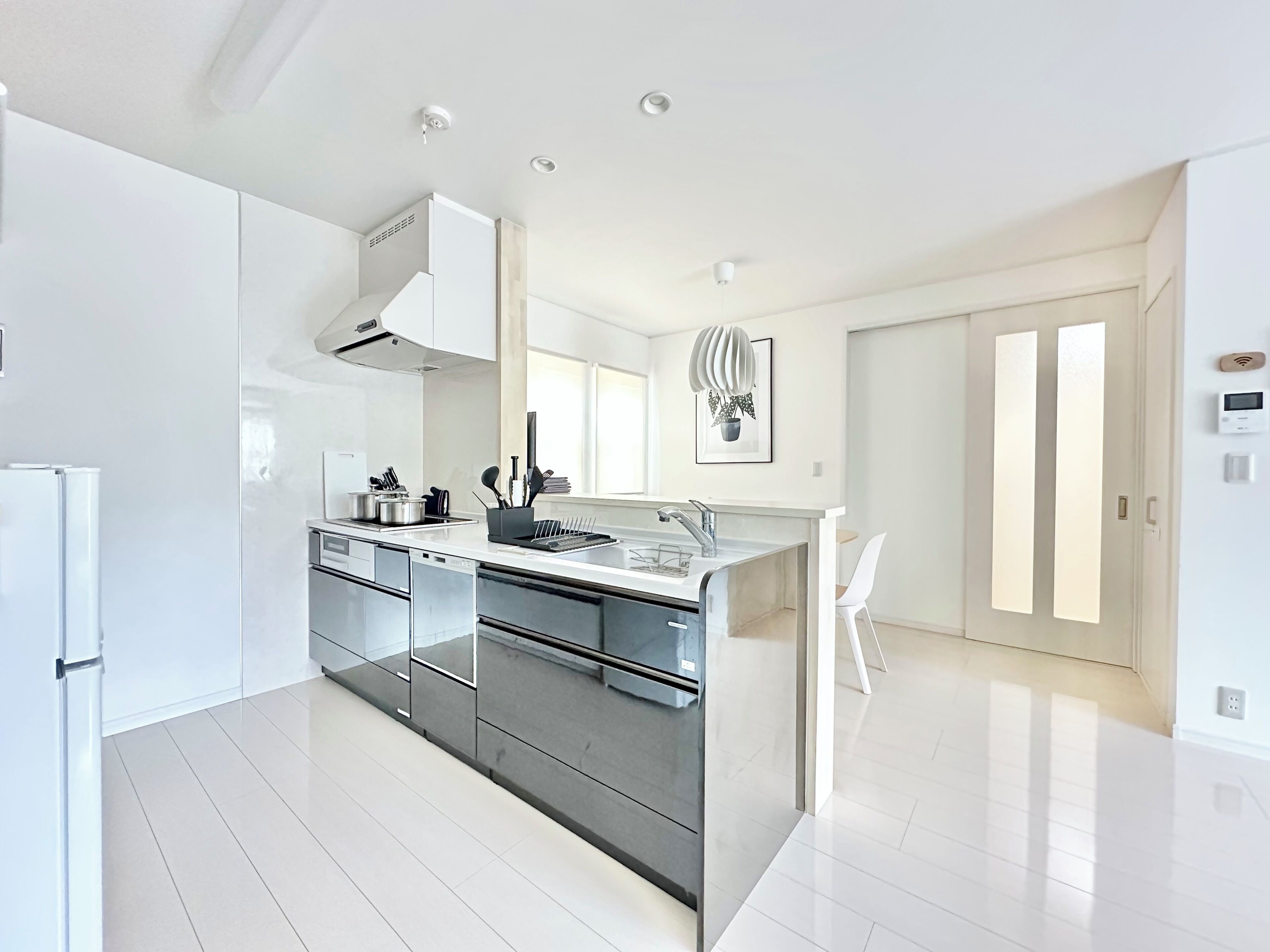 Una cocina moderna con una isla central, electrodomésticos de acero inoxidable y un amplio ventanal que proporciona luz natural.