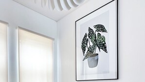 A conference room with a round table, chairs, a framed plant artwork, and a unique white vase. - Modern Property 15 Mins To Kumamoto Airport By Restavio (Ozu)