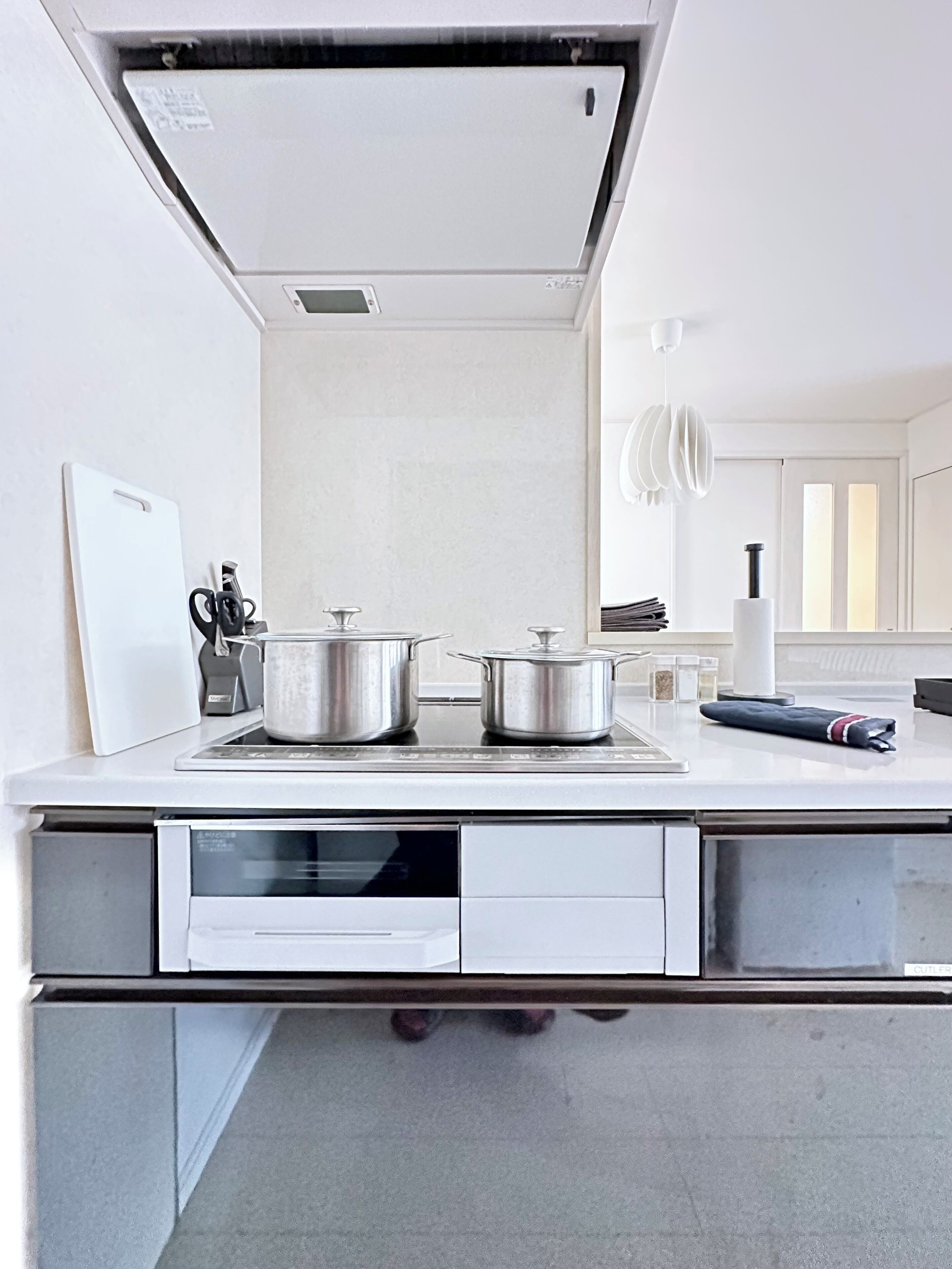 A modern kitchen with a built-in oven, a microwave, and a stainless steel countertop.