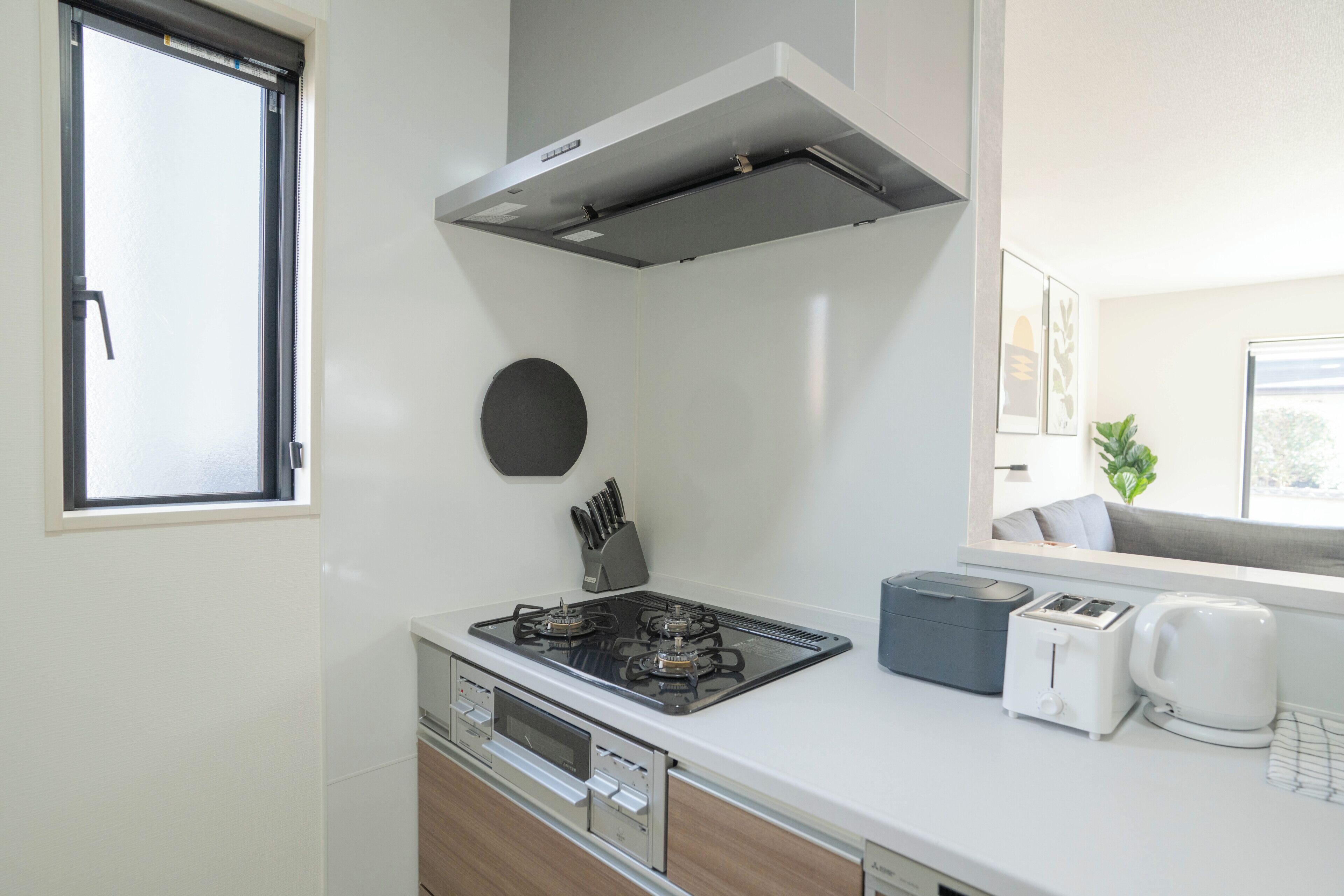 Una kitchenette compacta con estufa a gas, tostadora y cafetera.