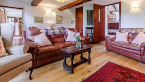 A cozy living room with leather sofas, a wooden coffee table, and a red patterned rug. - 3 Bed in Bakewell (oc-78618) (Gratton)