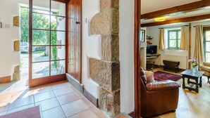 A spacious living area with a stone column, a leather sofa, and a television. - 3 Bed in Bakewell (oc-78618) (Gratton)