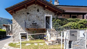 A stone building with a wooden roof, a metal balcony, and a gas meter. - Stunning private villa for 4 guests with WIFI, TV, terrace and pets allowed (Piuro)
