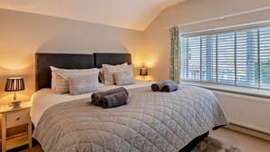 A bedroom with a bed, bedside lamps, a window with blinds, and a ceiling light fixture. - 3 Bed in Holt (oc-ncc46) (Holt)